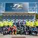 RST TT riders and travelling marshals in front of the podium