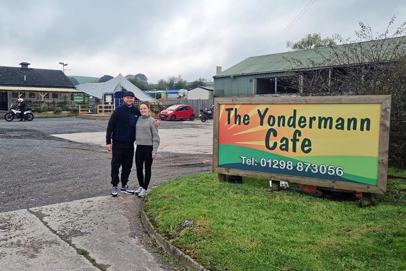 Couple standing by the Yondermann Café sign 
