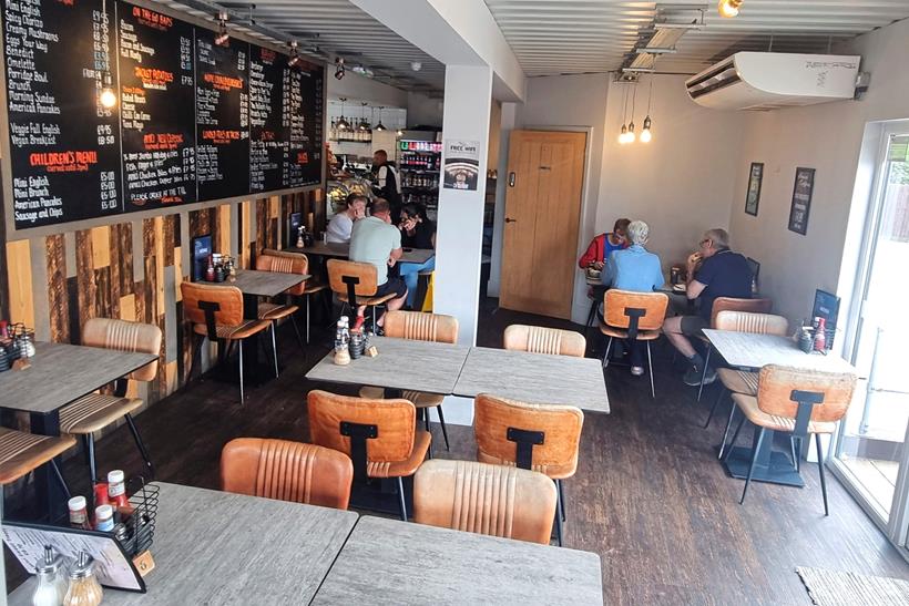 Inside the Amici Coffee with table and chairs with large menu on the wall