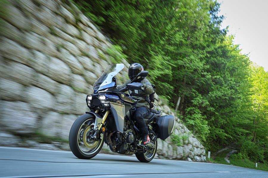 2025-on Yamaha Tracer 9 GT+ riding down a tree lined canyon road