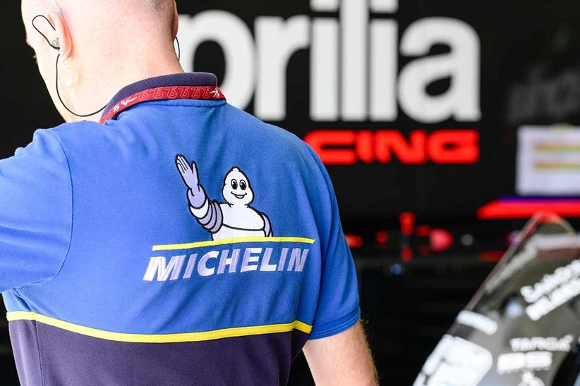 A Michelin engineer inside the Aprilia garage at the 2025 Sepang MotoGP test.