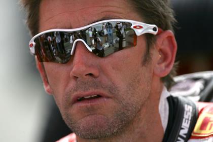 Troy Bayliss will arrive in Assen just in time for practice after being injured in a cycling crash