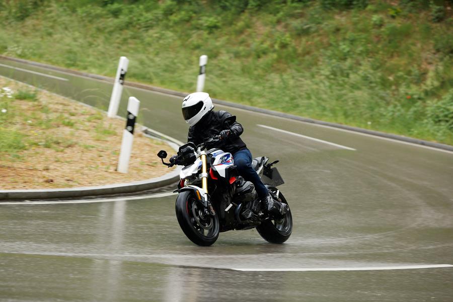 2025-on BMW R1300R carving corners on a wet road
