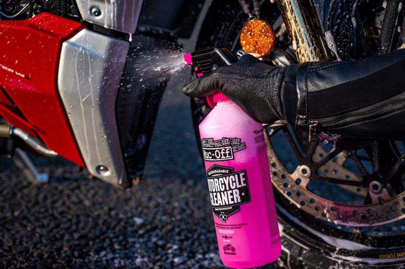 spraying Muc-Off on a bike