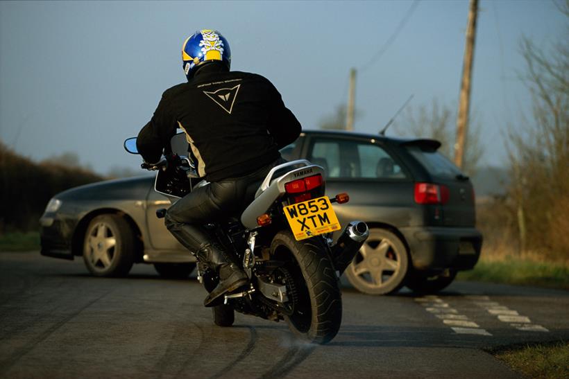 Biker skidding towards car