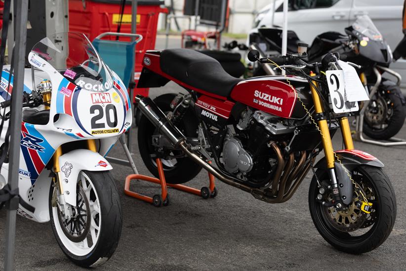 A pair of classic Suzukis parked in an awning
