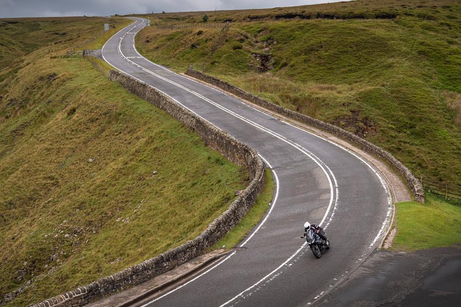 2025-on BMW R1300RS cruising down a country road 