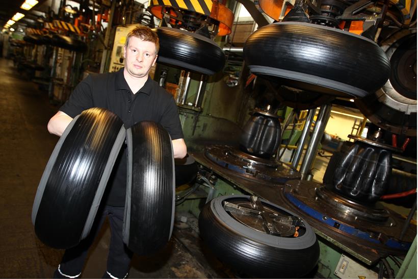 Continental employee holds up tyres ahead of tread being applied Continental employee holds up tyres ahead of tread being applied