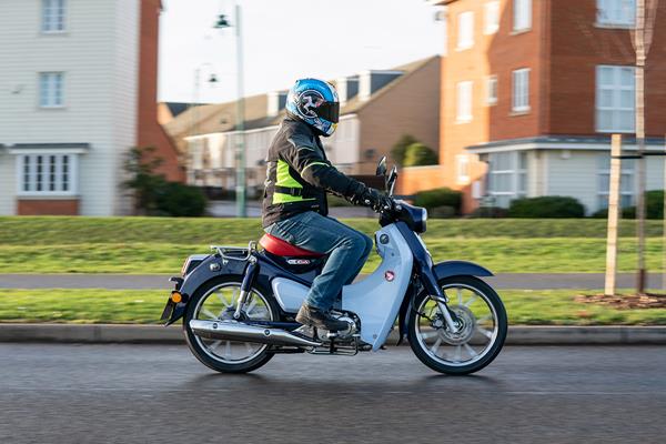 Honda Super Cub C125 riding shot side on