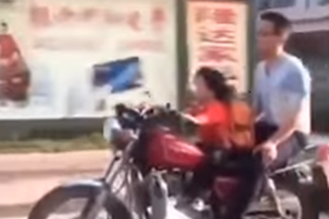 Toddler rides motorbike along busy streets with dad as pillion