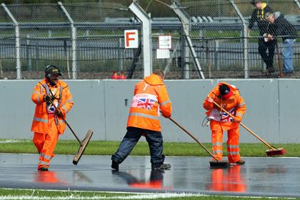 Marshals sweep water from the track at Silverstone 2018