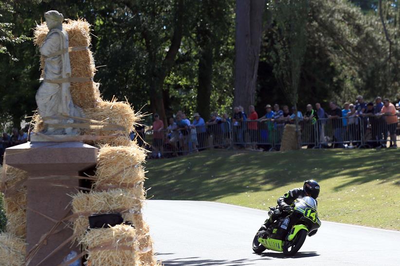 Bales of hay protect riders from a statue in Wales