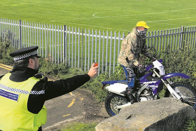 An officer sprays DNA at a motorcyclist