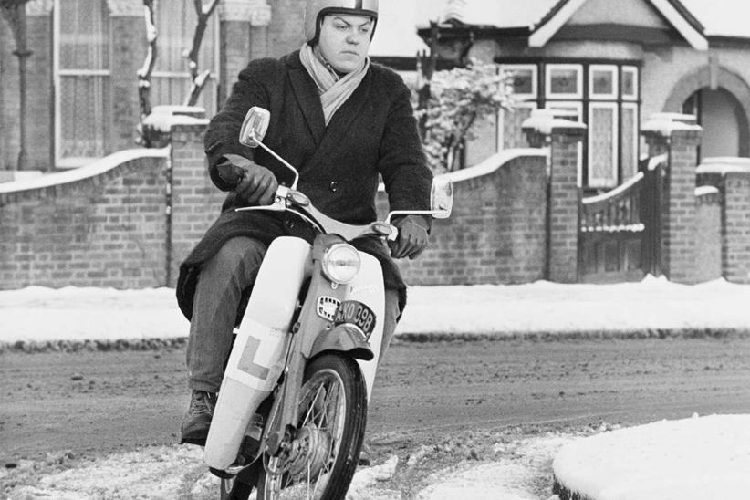 A C90 rider battles the elements circa 1964