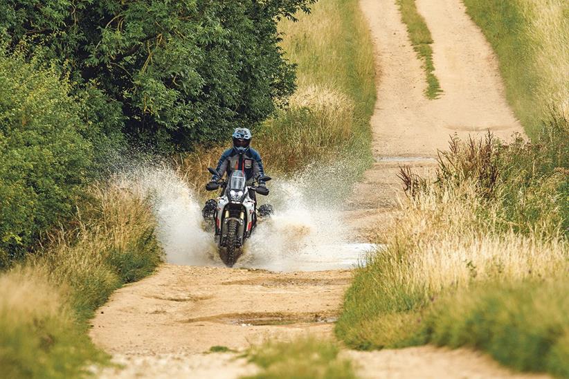 Yamaha Ténéré 700 splashing through a puddle with luggage