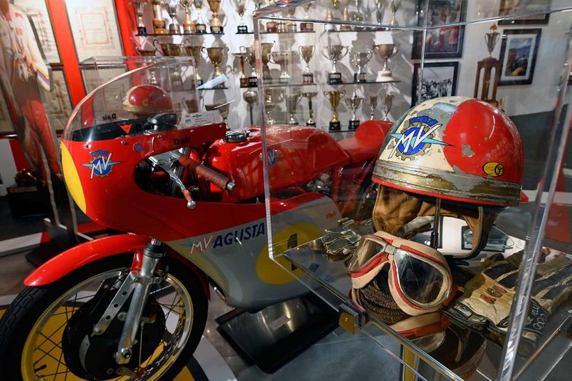 Helmets sit on display alongside classic race bikes