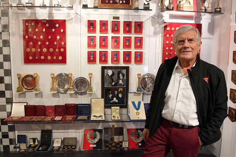 Agostini stands with some of his many awards