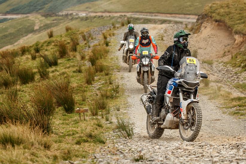 2022 Aprilia Tuareg 660 riding on a gravel trail in a rally