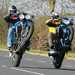 Two motorcyclists pull wheelies