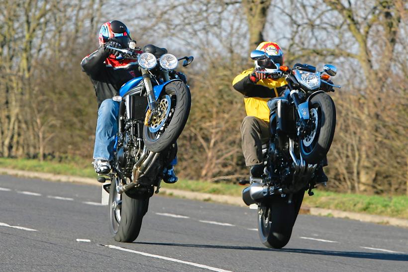 Two motorcyclists pull wheelies