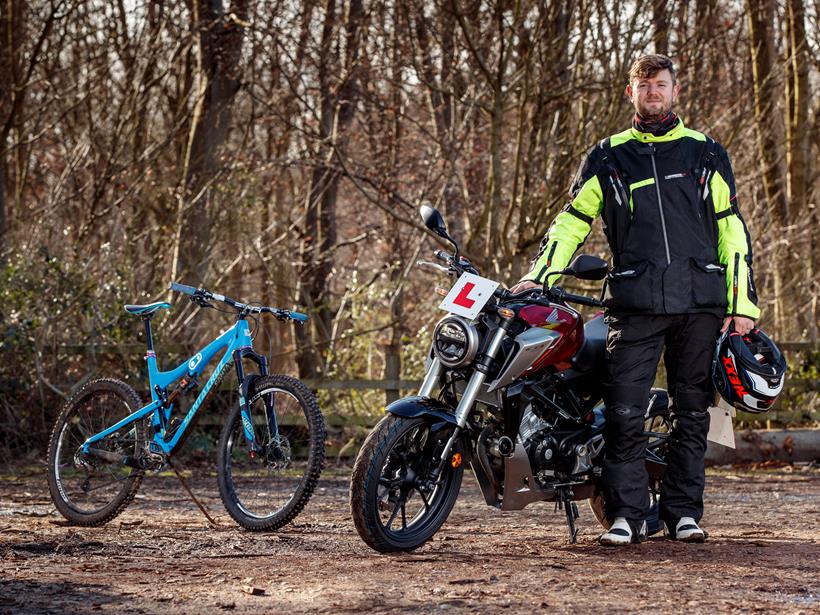 Adam poses with his mountain bike and the Honda CB125R