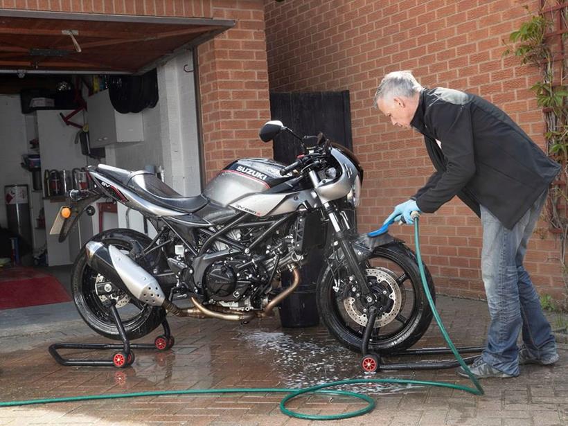 Clean motorbike with a hose