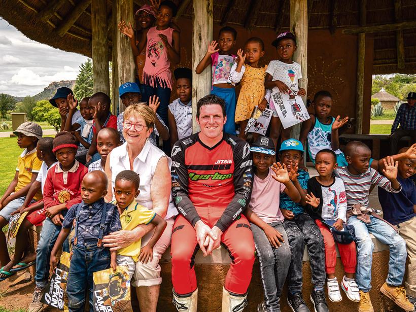 Dougie Lampkin with Riders for Health co-founder Andrea Coleman and local children