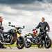 Two people stood next to a Triumph Speed 400 and Royal Enfield discussing