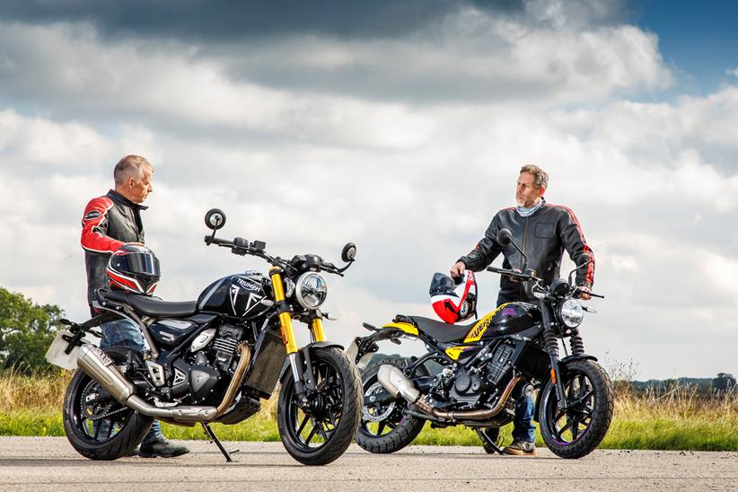 Two people stood next to a Triumph Speed 400 and Royal Enfield discussing