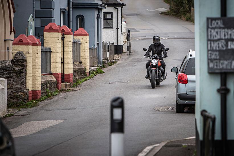 Moto Guzzi V7 rides through seaside village