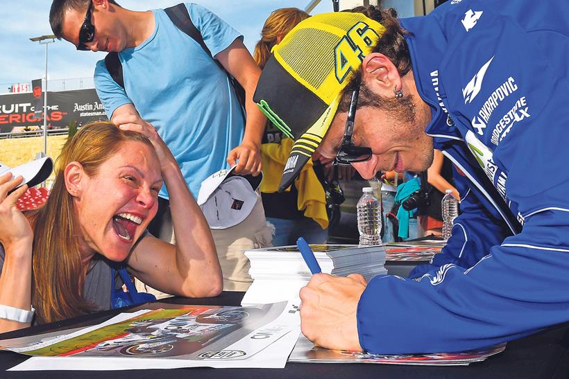 Valentino Rossi signing autographs for a fan