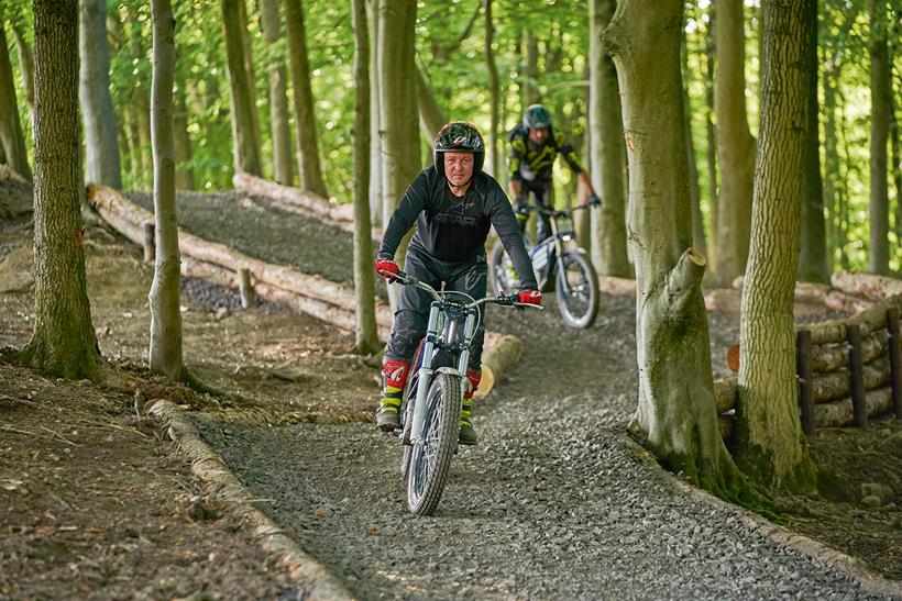 Riding an electric trials bike through woodland